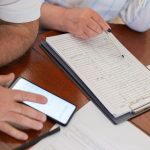 Dvije osobe pregledavaju dokumente za stolom