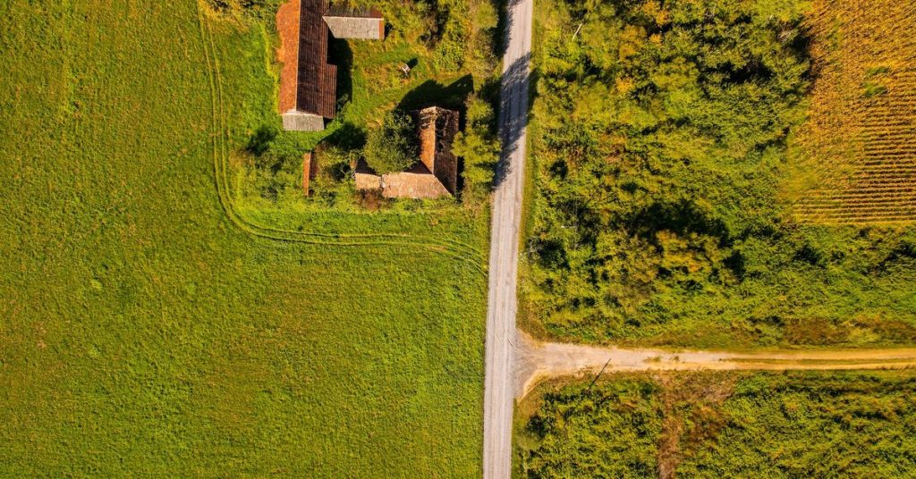 Pogled iz zraka na kucu okruzenu poljima