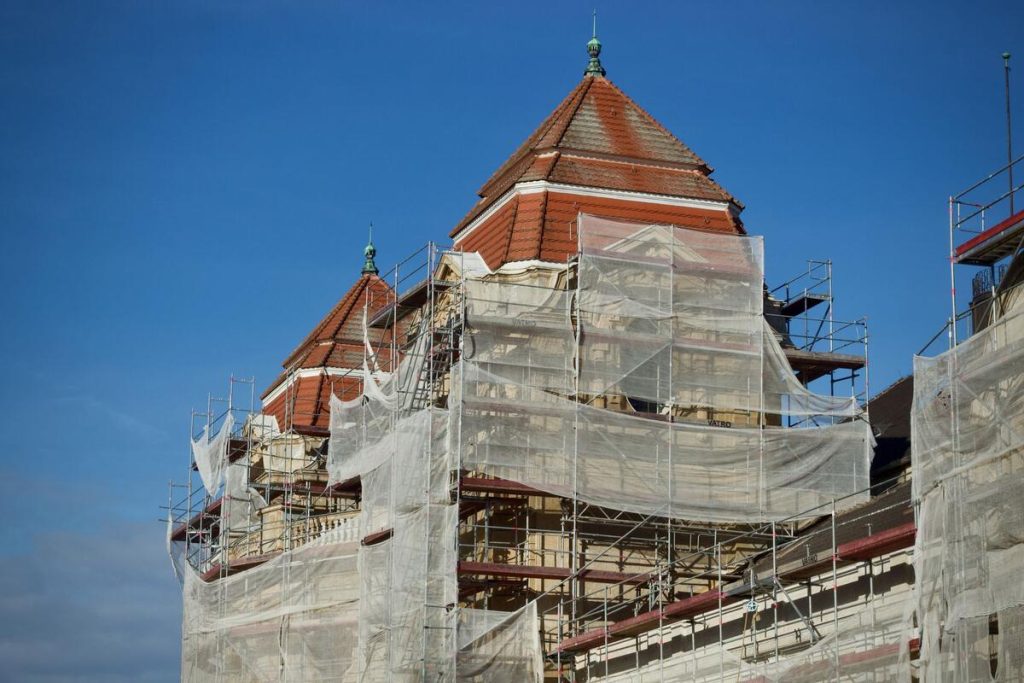 old brick house facade with scaffolding under renovation, no people visible